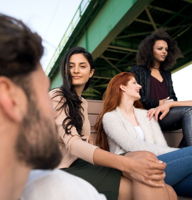 group of teens sitting on a bench